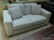 BRAND NEW TAMORA FABRIC LOVESEAT IN GRAY. A MODERN DESIGN COMBINED WITH LUXURIOUS, COMFORTABLE