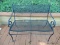 (OUT) CAST IRON AND MESHED WIRE PATIO BENCH WITH SCROLL STYLE ARMS. MEASURES 39 IN X 24 IN X 31 IN.