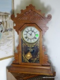 (FAM) ANTIQUE OAK WATERBURY GINGERBREAD CLOCK WITH KEY AND PENDULUM- 22 IN , ITEM IS SOLD AS IS
