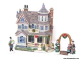 HOLIDAY VILLAGE BUILDING OF A VICTORIAN STYLE HOME WITH A SNOWMAN OUT FRONT, ALSO INCLUDES 2