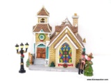 HOLIDAY VILLAGE BUILDING OF ST. MARKS CHURCH WITH AN ADDITIONAL FIGURINE OF A COUPLE (WOMAN IS