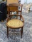 (R1) VICTORIAN WALNUT HIP REST SIDE CHAIR WITH CANE BOTTOM SEAT AND SPINDLE LEG SUPPORTS. MEASURES