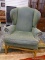 (R1) HICKORY HOUSE GREEN UPHOLSTERED WINGBACK CHAIR WITH BRASS STUDDING AROUND THE EDGES AND PECAN