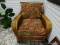 (R2) RATTAN AND WICKER ARM CHAIR WITH FLORAL UPHOLSTERED CUSHIONS. IS 1 OF A PAIR. MEASURES 34 IN X