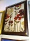 (R2) FRAMED FLORAL PRINT IN HUES OF RED, BROWN, AND CREAM. MEASURES 27 IN X 34 IN. ITEM IS SOLD AS