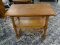 (R1) 2 TIER OAK END / SIDE TABLE WITH STRETCHER BASE. MEASURES 14 IN X 26 IN X 22 IN. ITEM IS SOLD