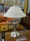 (R1) SILVER TONE AND FROSTED GLASS SHADE DOUBLE LIGHT LAMP WITH SILVER TONE FINIAL. MEASURES 20 IN