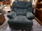 (R1) OVERSIZED GREEN UPHOLSTERED RECLINER WITH ROLLED ARMS. MEASURES 38 IN X 40 IN X 46 IN. ITEM IS