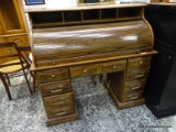 (R1) OAK ROLL TOP DESK WITH UPPER AND INTERIOR FILING AREAS, AND 7 DRAWERS ON THE BASE. MEASURES 51