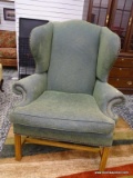 (R1) HICKORY HOUSE GREEN UPHOLSTERED WINGBACK CHAIR WITH BRASS STUDDING AROUND THE EDGES AND PECAN