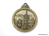 (SC) BRASS NECKLACE PENDANT WITH A PAGODA ON 1 SIDE AND FAR EASTERN WRITING ON THE OPPOSING SIDE. IS