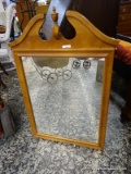 (R2) FRAMED MIRROR WITH BROKEN ARCH PEDIMENT TOP AND CENTER FINIAL ON THE CREST. MEASURES 24 IN X 36