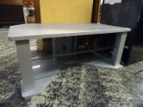 (R1) GRAY TV STAND WITH 2 LOWER GLASS SHELVES. MEASURES 43 IN X 24 IN X 18 IN. ITEM IS SOLD AS IS,