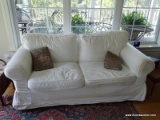 (mbr) white covered love seat- 65 in x 33 in x 34 in. ITEM IS SOLD AS IS WHERE IS WITH NO GUARANTEES