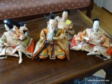 (UPBED 2) LOT OF 4 JAPANESE STYLE DOLLS. 2 ARE MEN, 1 IS A WOMAN, AND 1 IS OF AN ELDERLY SAMURAI
