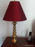 (DLR) BRASS TABLE LAMP WITH RED BELL SHAPED SHADE. MEASURES 30 IN TALL. ITEM IS SOLD AS IS WHERE IS
