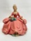 (S8H) CERAMIC OR CHALKWARE FIGURE NEOCLASSICAL SEATED LADY WITH PINK DRESS AND FLOWER BASKET (9.5