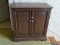 (STAIRS) WALNUT FINISHED 2 DOOR CABINET- 26.5 IN X 13 IN X 28 IN, ITEM IS SOLD AS IS WHERE IS WITH