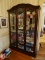 (PARLOR) ONE OF A PR. OF CHERRY 2 DOOR DISPLAY CABINETS, BEVELED GLASS DOORS AND CENTER PANEL WITH