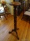 (PARLOR) MAHOGANY CARVED CANDLE STAND WITH CARVED GRAPES AND LEAVES, RESTING ON PAW FEET- 10 IN DIA,