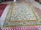 CHINESE SCULPTED AREA RUG IN IVORY, GREEN, AND FLORAL. MEASURES APPROXIMATELY 10 FT X 14 FT. ITEM IS