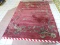 VINTAGE MACHINE MADE ORIENTAL RUG IN MAROON AND GREEN. SHOWS MOTH DAMAGE. MEASURES APPROXIMATELY 8