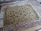 MACHINE MADE ORIENTAL STYLE AREA RUG IN BEIGE AND RUST. IN THE SPHINX PATTERN. MEASURES