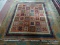 HANDMADE ORIENTAL RUG IN BROWN, IVORY, AND RED WITH BEIGE COLORED TASSELS. MEASURES APPROXIMATELY 6