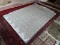 MACHINE MADE DESIGNER RUG IN GRAY AND WHITE. MEASURES APPROXIMATELY 5 FT X 7 FT. ITEM IS SOLD AS IS