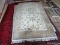 HAND TUFTED ORIENTAL STYLE RUG IN IVORY, SAGE, AND RED. MEASURES APPROXIMATELY 6 FT X 8 FT 2 IN.