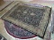 MACHINE MADE PERSIAN STYLE RUG IN BLACK, IVORY, SAGE. MEASURES 5 FT 3 IN X 7 FT 9 IN. ITEM IS SOLD
