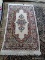 MACHINE MADE ORIENTAL STYLE RUG IN IVORY, RED, AND SAGE. MEASURES APPROXIMATELY 2 FT 7 IN X 4 FT 11
