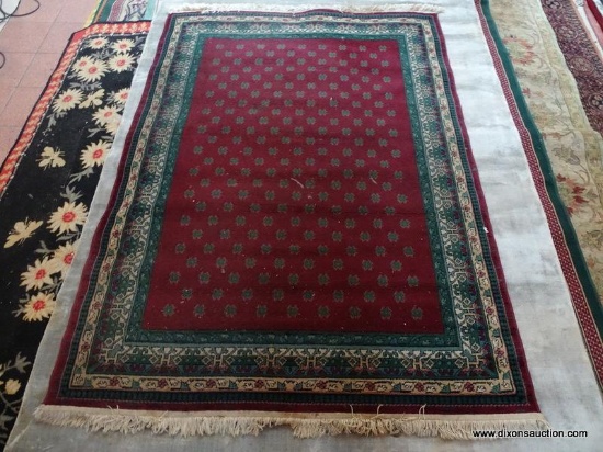 MACHINE MADE ORIENTAL STYLE IN BURGUNDY, GREEN, AND BEIGE. MEASURES APPROXIMATELY 5 FT 4 IN X 7 FT 8