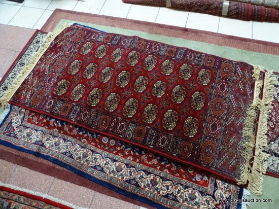 HANDMADE MACHINE TURKISH RUG IN MAROON, IVORY, AND BLUE. MEASURES APPROXIMATELY 3 FT X 6 FT. ITEM IS