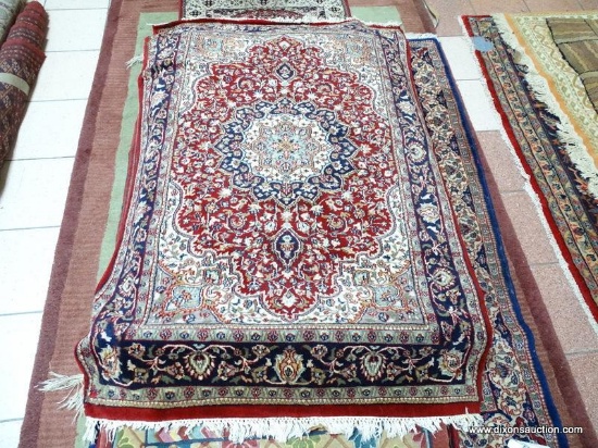 HANDMADE PERSIAN IN RED, IVORY, AND BLUE. MEASURES APPROXIMATELY 3 FT 10 IN X 5FT 9 IN. ITEM IS SOLD