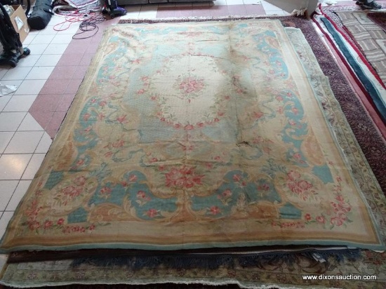 ESTATE OWNED VINTAGE HANDMADE TAPESTRY RUG. HAS SOME DAMAGE. IS BLUE, MAUVE AND IVORY IN COLOR.