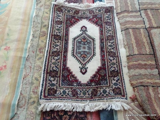 HANDMADE INDIAN RUG IN IVORY, BLUE, AND RED. MEASURES APPROXIMATELY 2 FT X 3 FT. ITEM IS SOLD AS IS