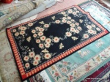 MACHINE MADE HOOK RUG WITH FLOWERS AND BEES IN BLACK, IVORY, AND RED. MEASURES APPROXIMATELY 5 FT X