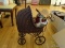(LR) WICKER DOLL CARRIAGE WITH ANTIQUE COMPOSITION DOLL WITH MOVEABLE ARMS AND LEGS- CARRIAGE- 14 IN