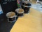 (BAY 7) SET OF 4 ASSORTED SIZE DRUMS WITH BLACK FINISH. ITEM IS SOLD AS IS WHERE IS WITH NO