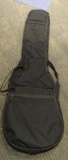 (SC) SOFT CASE GUITAR CARRYING BAG. HAS A SMALL HOLE IN THE BOTTOM OF THE CASE. ITEM IS SOLD AS IS