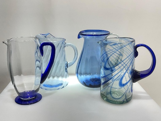 (2B) FOUR BLUE GLASS PITCHERS INCLUDING HAND BLOWN 9.5 INCH PITCHER (POSSIBLY NOVICA FIESTA);