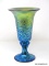 Footed vase with brilliant blue and gold iridescent and king Tut design. Created by Lundberg