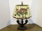 Double Light Rose Pattern Slagged Glass Lamp With Bronze Tone Base. Measures 14 In X 22 In. Item Is