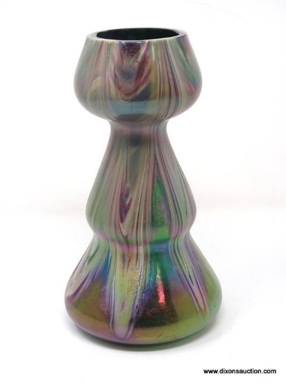 A translucent, gourd shaped green glass having surface decoration of opaque white and purple swirls.