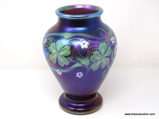 Purplish brown iridized glass with surface decoration of green and white floral motif having