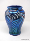 A metallic iridescent blue vase having a wide mouth with a slightly rolled lip above wide shoulders
