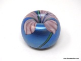 Blue paperweight pen holder decorated with 5 petaled lavender & white veined flower. Two green stems
