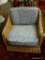 (R3) WICKER ARM CHAIR WITH BLUE FLORAL UPHOLSTERED CUSHIONS. IS 1 OF A PAIR. MEASURES 29 IN X 35 IN