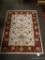 (R3) BURGUNDY AND CREAM FLORAL AREA RUG. MEASURES 3 FT 3 IN X 4 FT 8 IN. ITEM IS SOLD AS IS WHERE IS